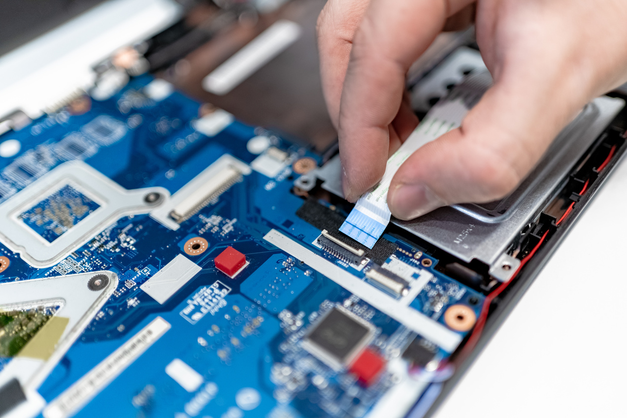 technician carefully connecting flex cable of the daughter board with fingers